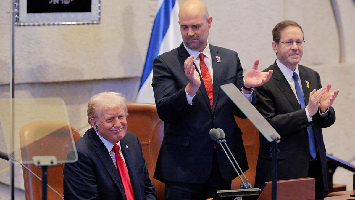 Prezydent Donald Trump uśmiecha się, gdy otrzymuje owację na stojąco