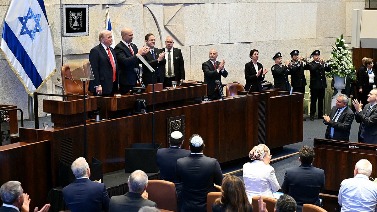 US President Donald Trump (L) receives a standing ovation before speaking at the Israeli parliament, the Knesset.