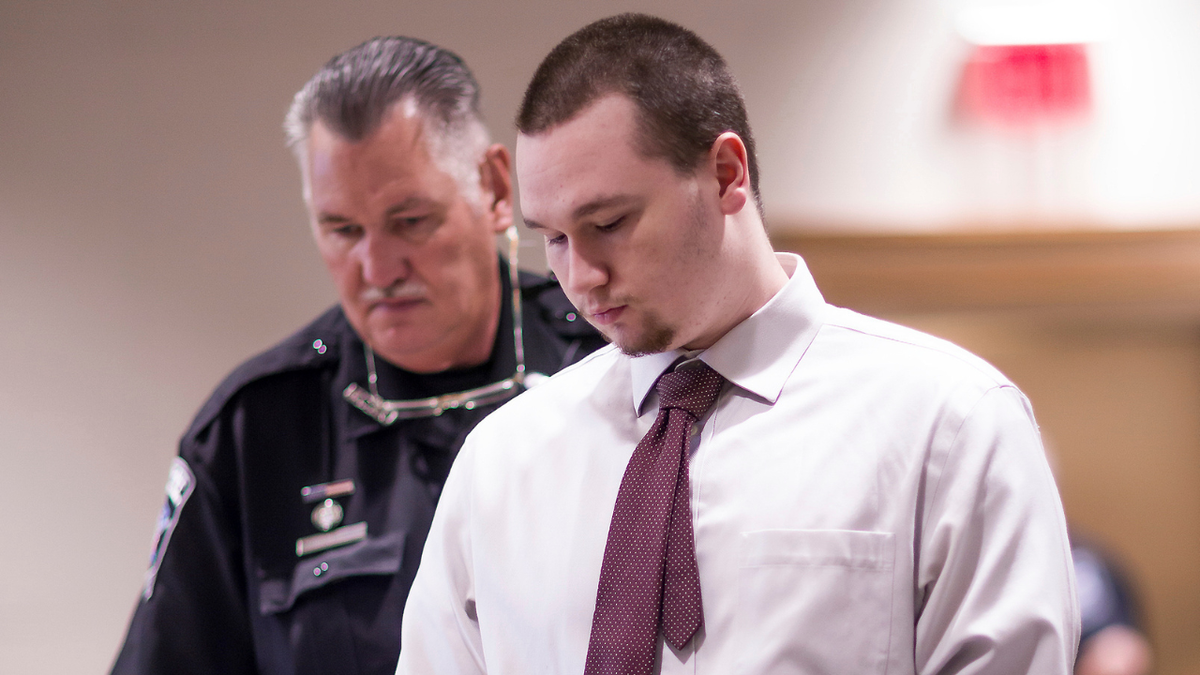 Eric Sweeney looks down in court as officer stands behind him during sentencing in Concord, N.H.