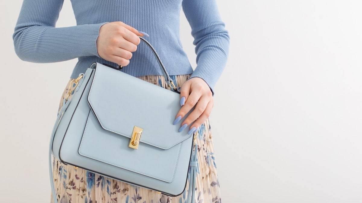 woman holding blue purse