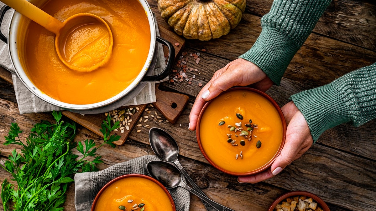 serving pumpkin soup with fall decor