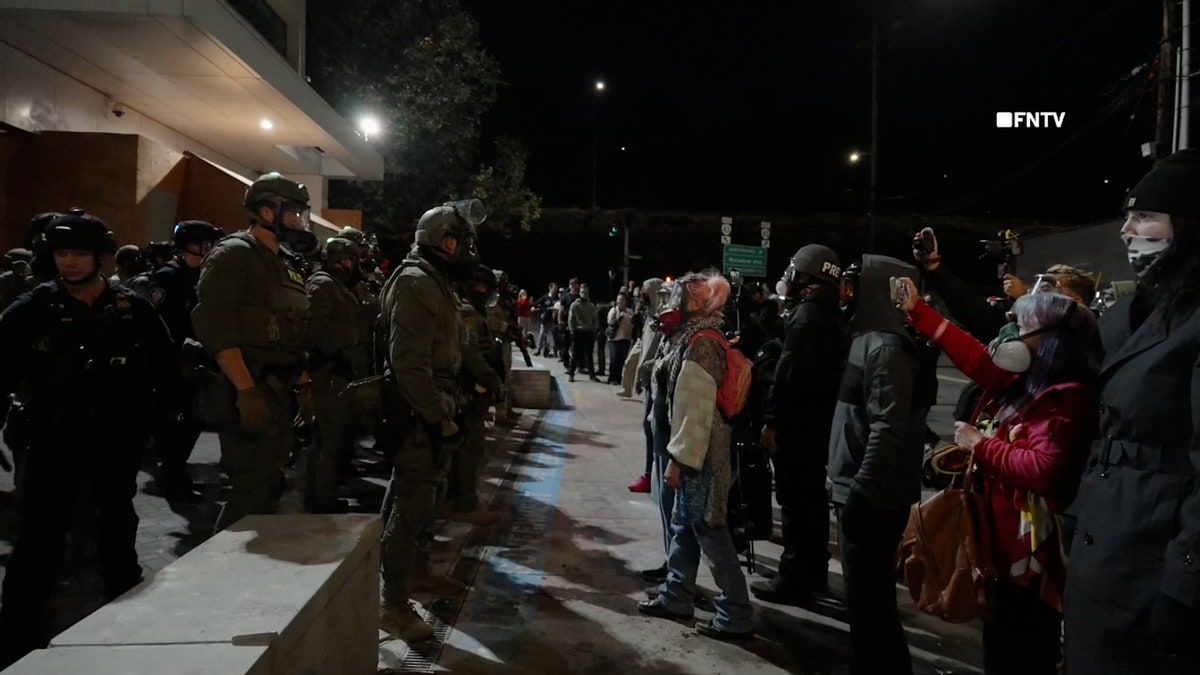 Federal troops and protests standing next to the line during the conflict