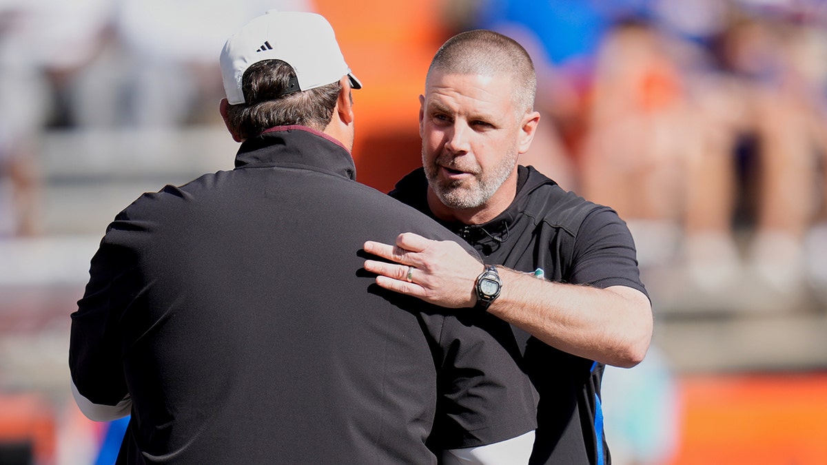 Billy Napier e Jeff Lebby se abraçam