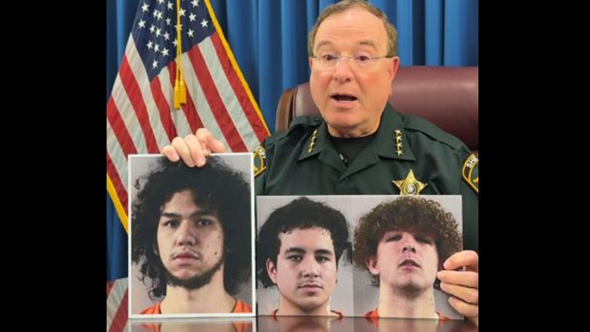 Sharif holds photos of three suspects
