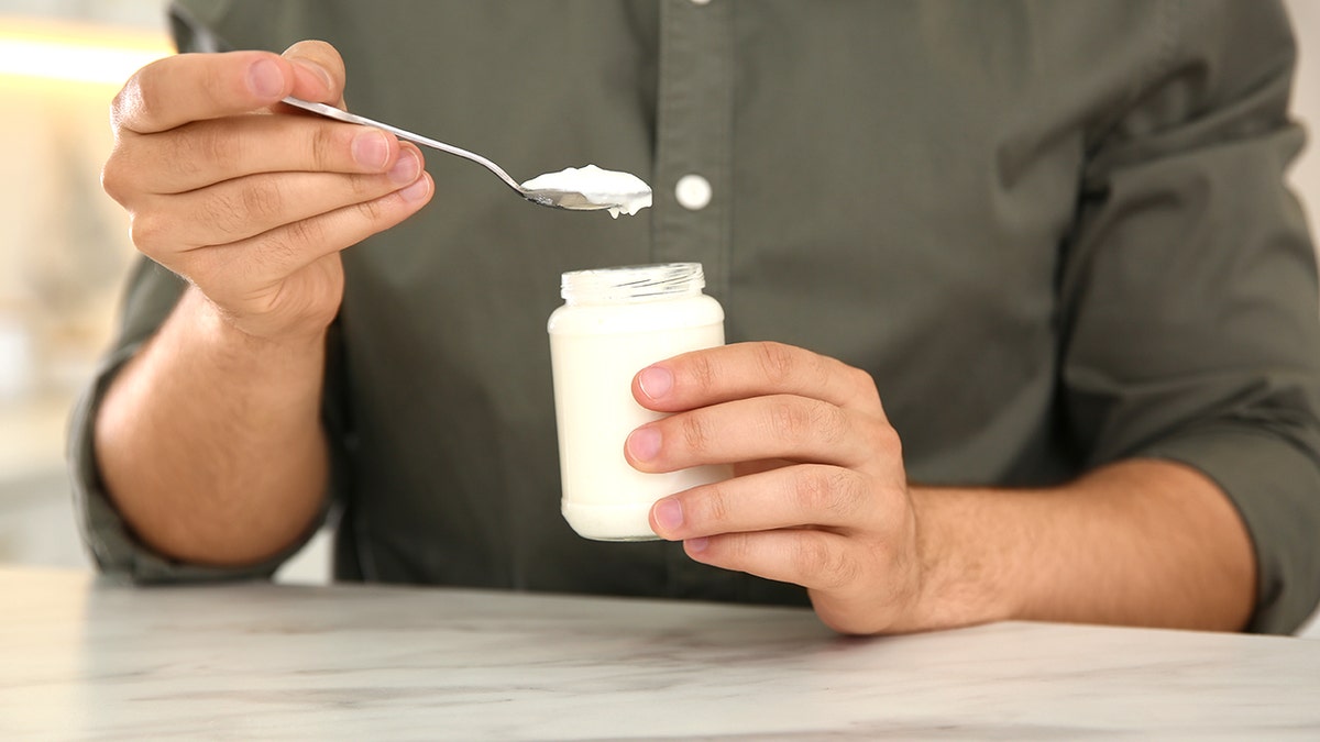 Man holding greek yogurt cup