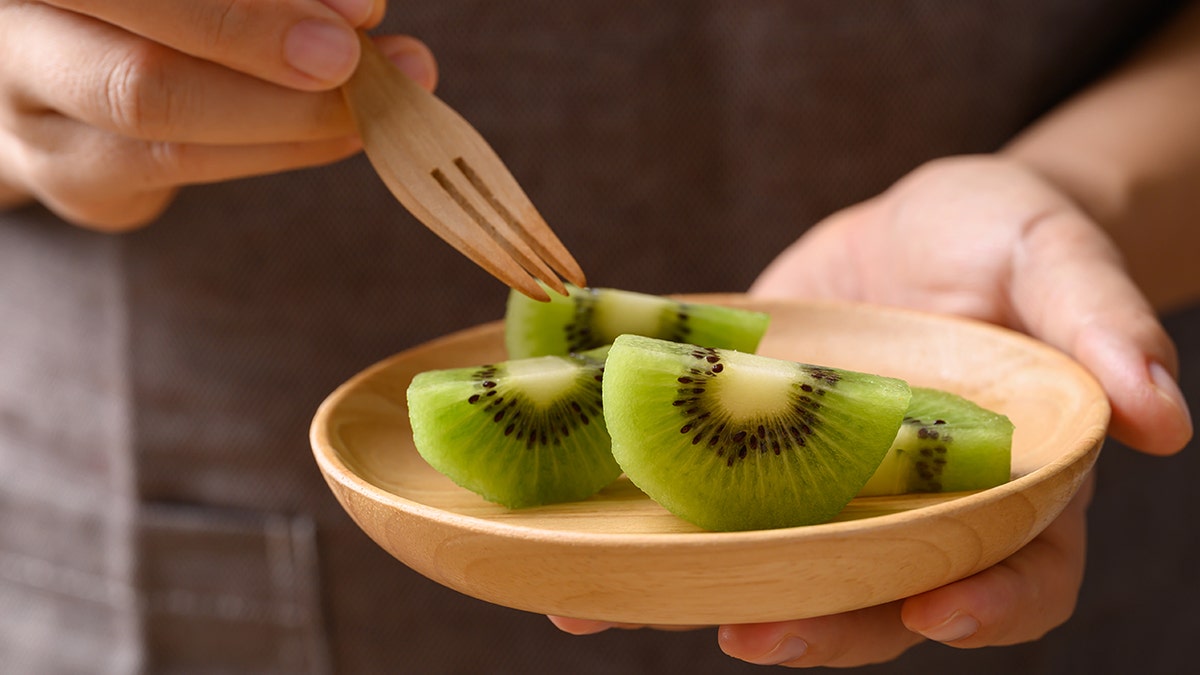 Person eating kiwis