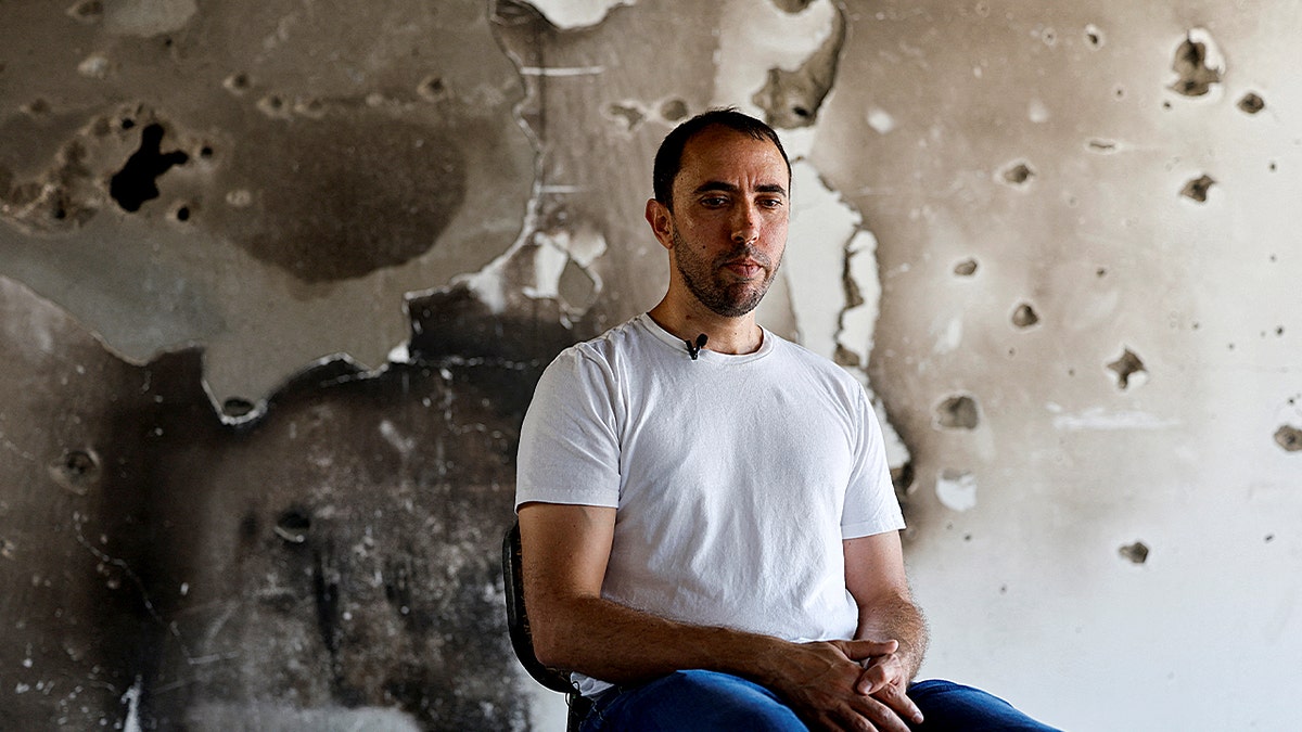 Tal Shoham sitting holding his hands together.