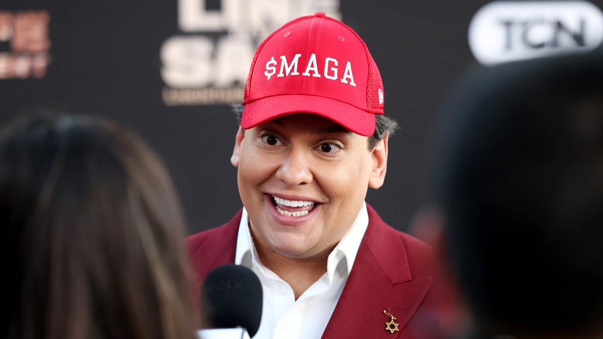 George Santos wearing a hat that reads $MAGA