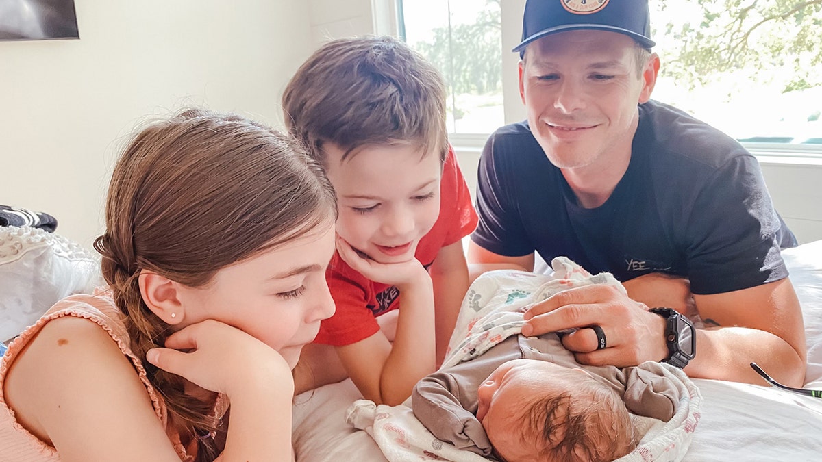 Granger Smith and his two older children admiring baby Maverick.