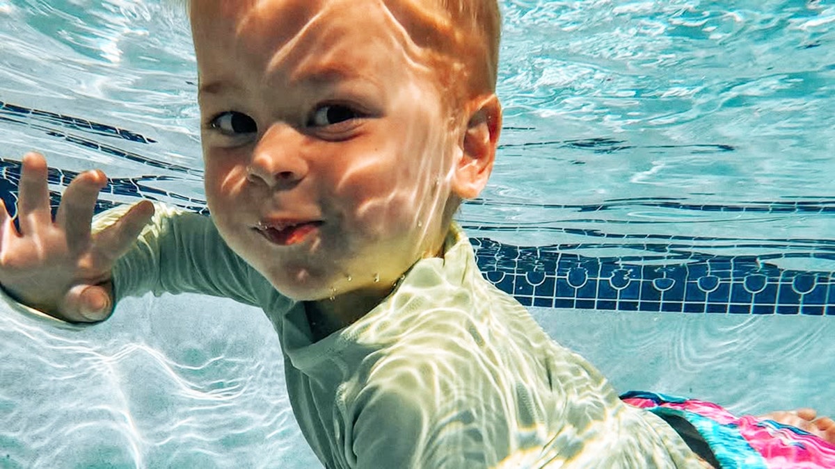 Maverick Smith under water swimming and smirking.