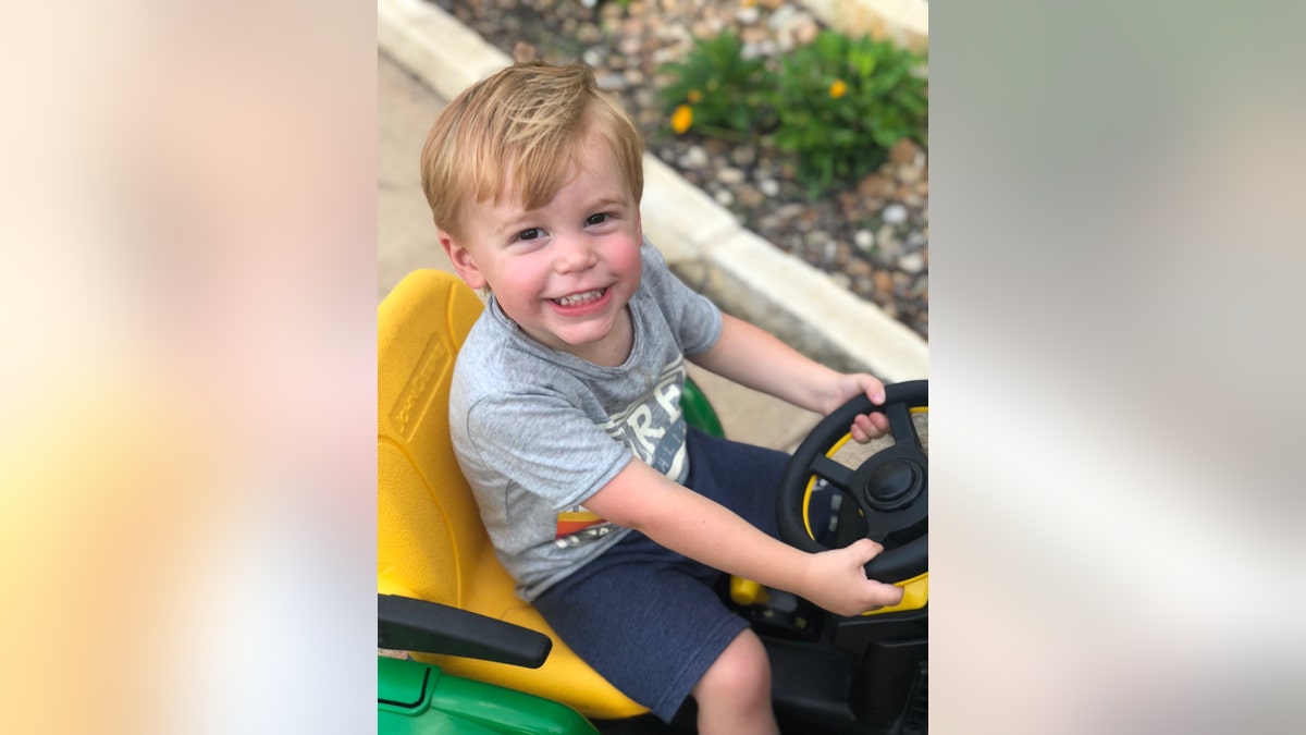 River Smith smiling and riding his factor tractor.