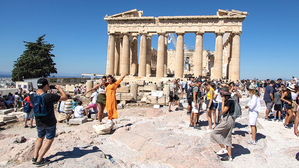 Tourists pose for photo outside temple