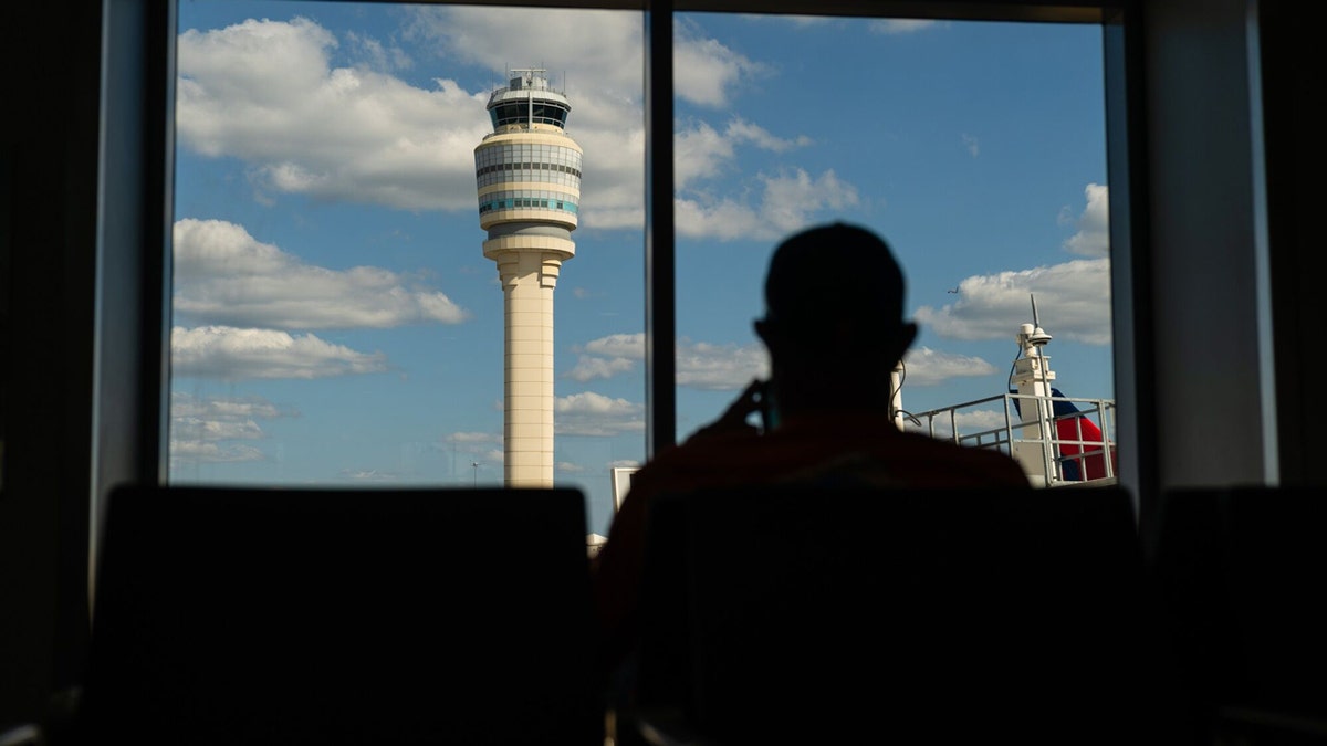 Passenger looking at tower outside window at airport