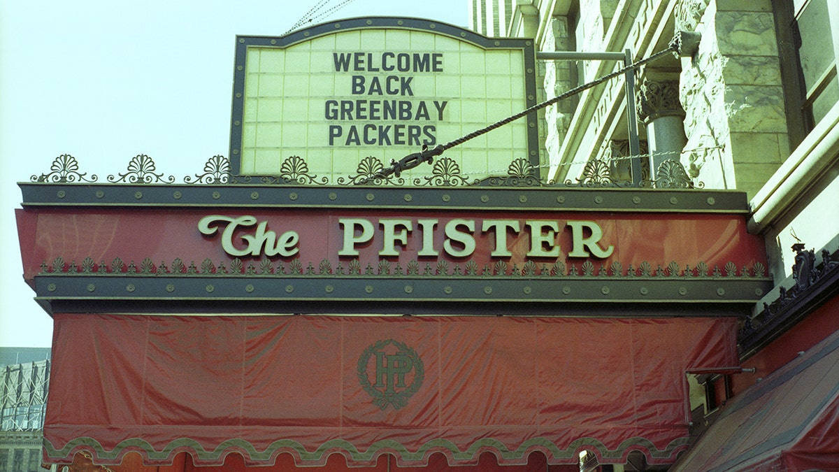 Vintage photo of Pfister Hotel sign from 1981, with "welcome back Greenbay Packers" marquee sign above it.