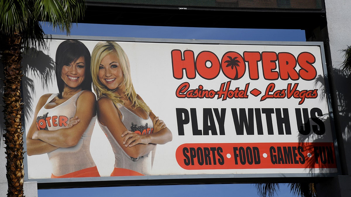 A billboard for the Hooters Casino Hotel in Las Vegas is shown. It says, "Play With Us."