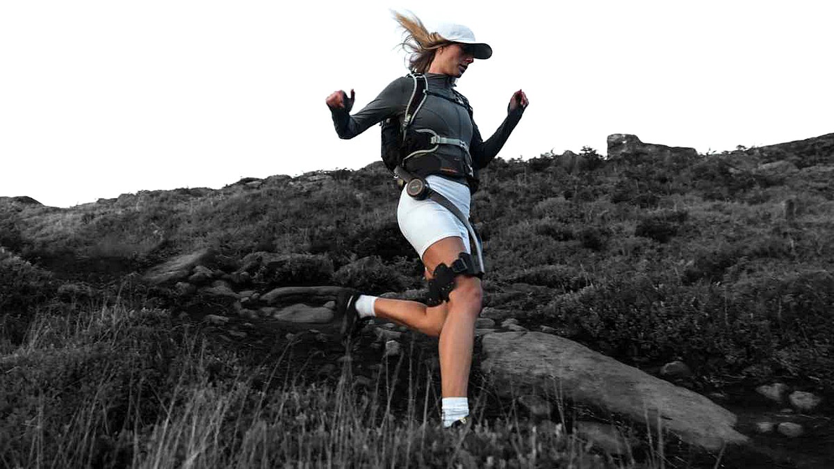 A woman hiking while wearing the Hypershell X Ultra exoskeleton