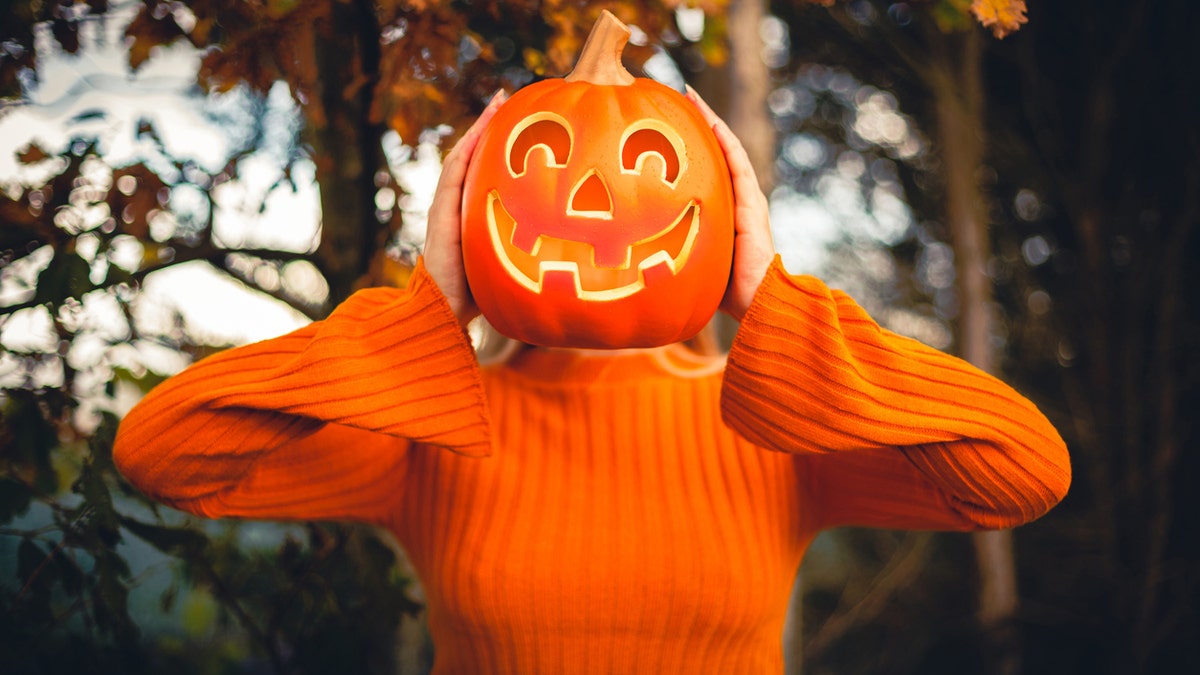 Turn a simple orange sweatshirt into a jack-o-lantern costume.