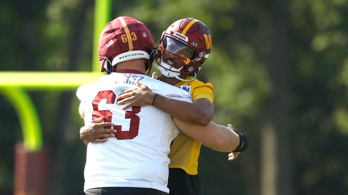 Jayden Daniels and Tyler Biadasz hug