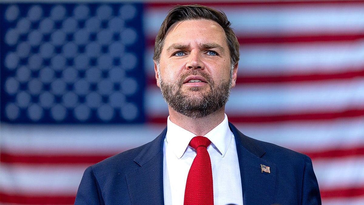 Vice President JD Vance speaks with the backdrop of a large American flag