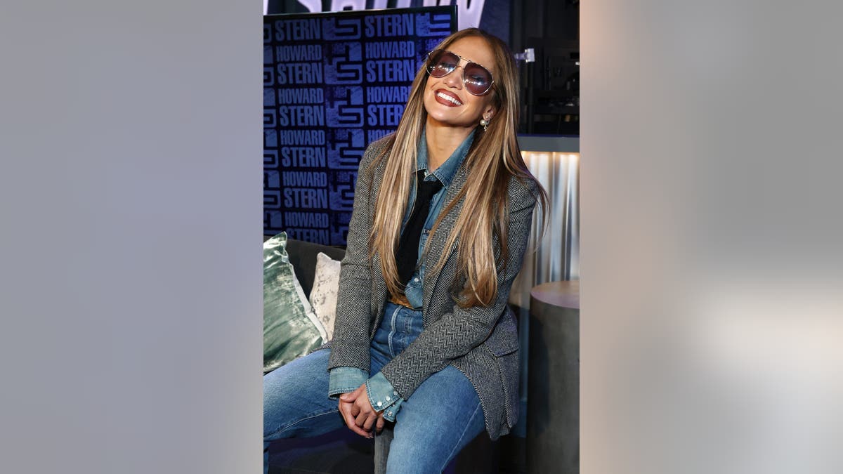 Jennifer Lopez sorrindo com óculos de sol