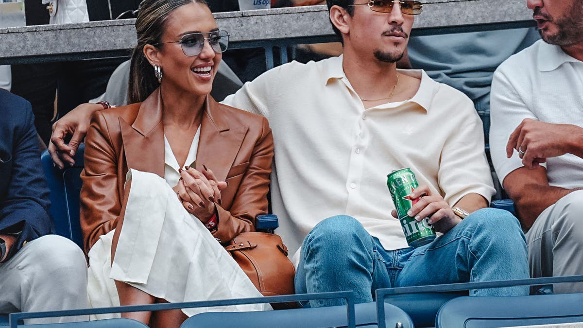 Jessica Alba and Danny Ramirez sit together in the stands at the 2025 US Open in New York City on September 7, 2025.