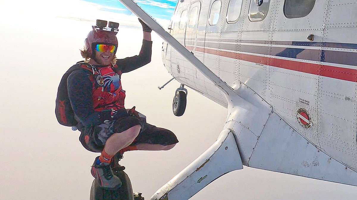 Justin Fuller hangs off a plane