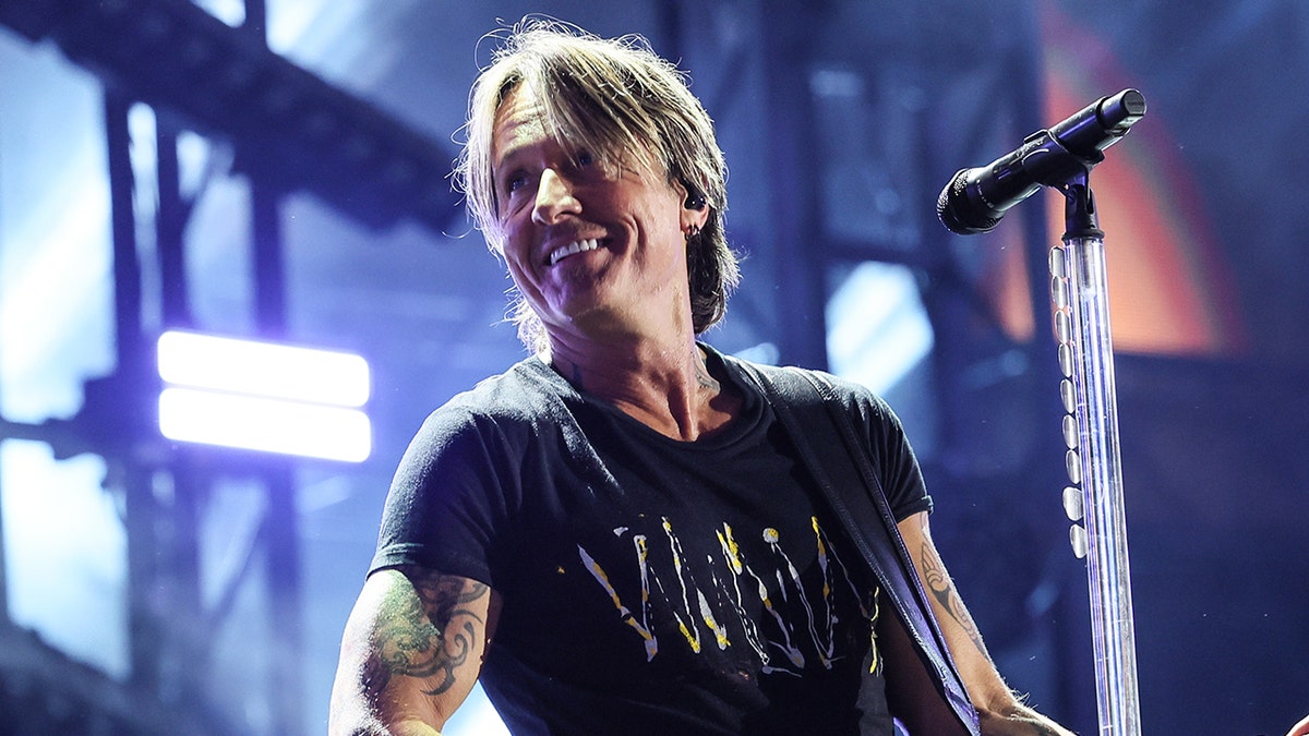 Keith Urban wearing a black shirt while on stage at CMA Fest in June 2025.