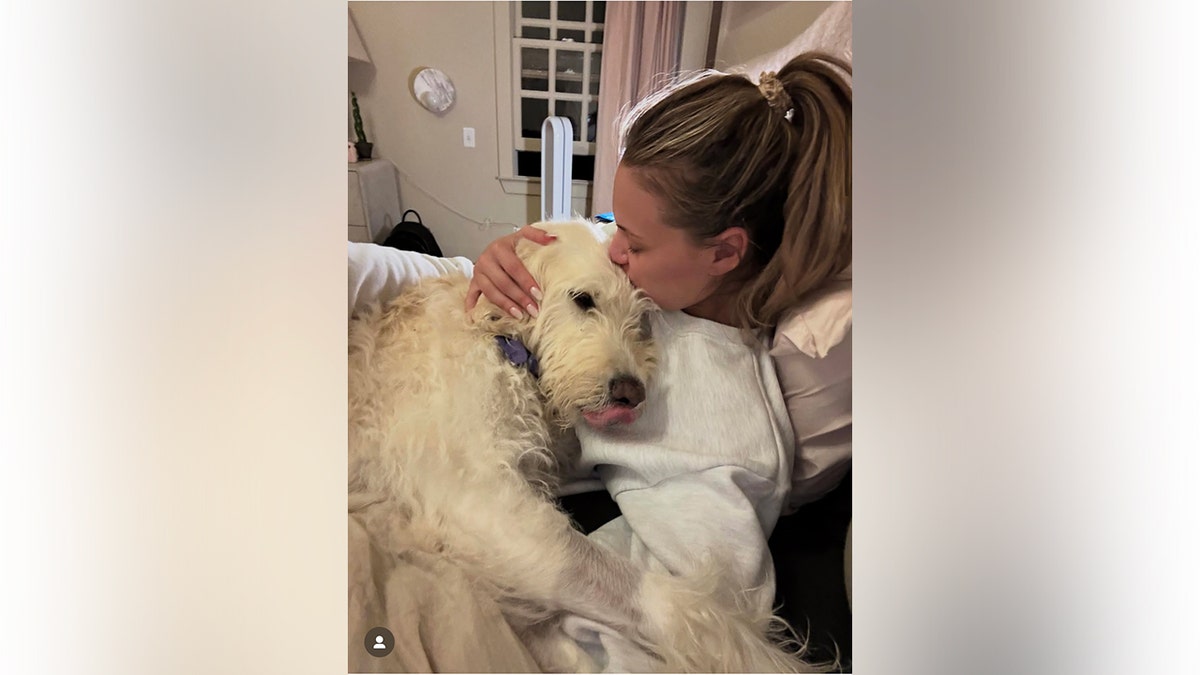 Kelsea Ballerini abraçando seu cachorro Dibs