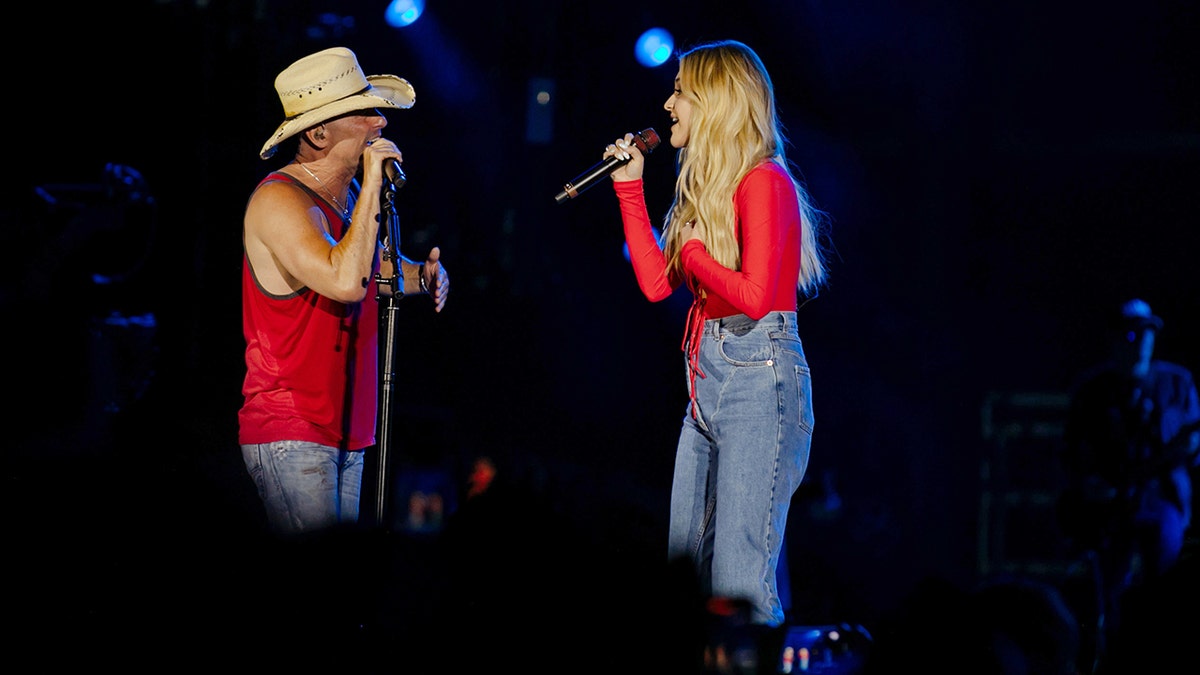Kenny Chesney e Kelsea Ballerini cantando no palco