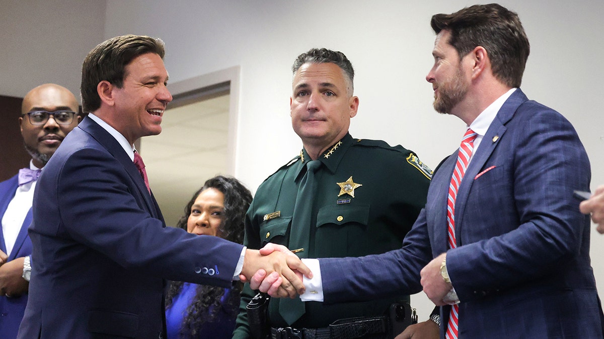 Florida Gov. Ron DeSantis shakes hands with state Rep. Kevin Steele