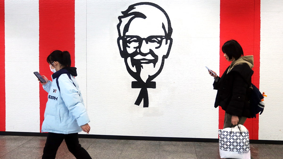 New Yorkers walk past KFC logo