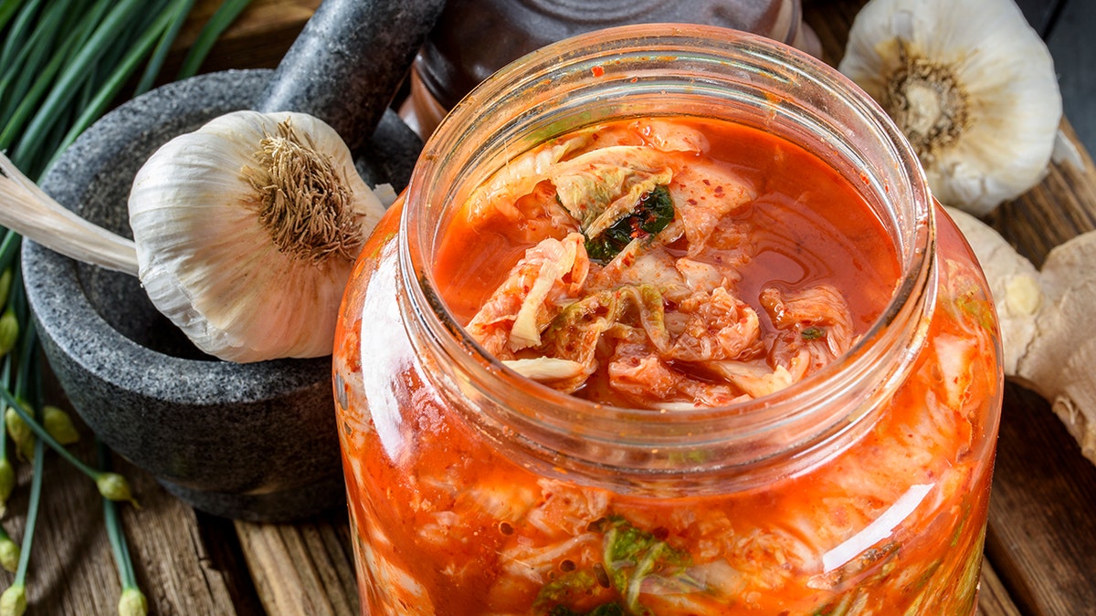 View of kimchi jar with cabbage, garlic