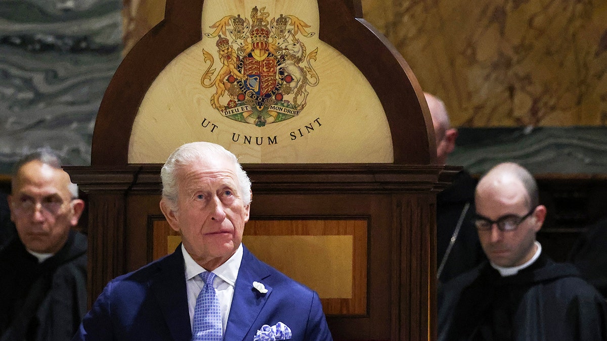 King Charles III looking up in a blue suit during mass.