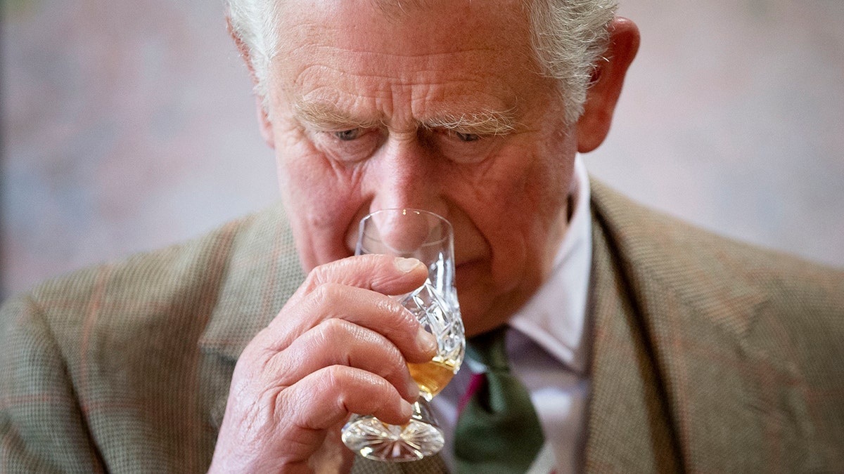 King Charles smelling a glass of whisky.