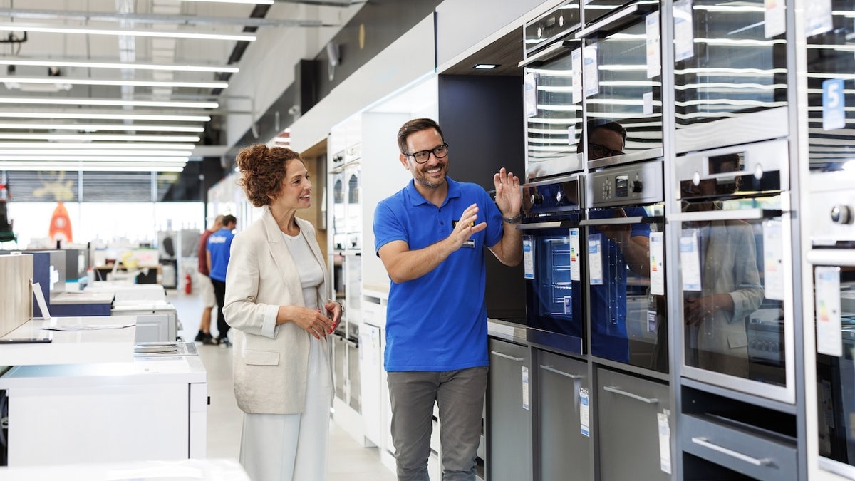 salesperson showing kitchen appliances