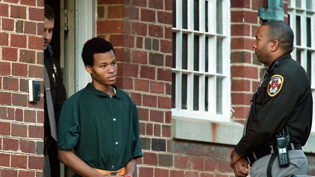 Lee Boyd Malvo, diborgol, dikawal polisi.