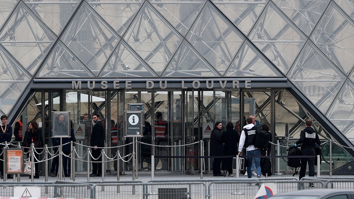 Forensic police officers arrive at the Louvre