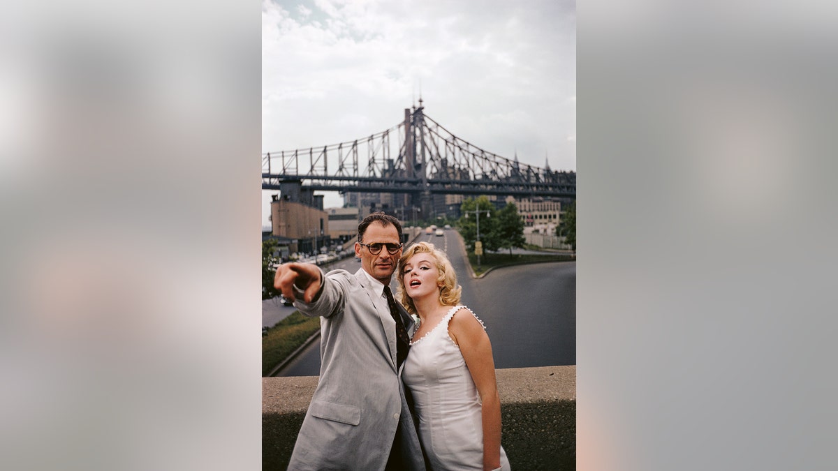 Arthur Miller pointing something at Marilyn Monroe in New York City.