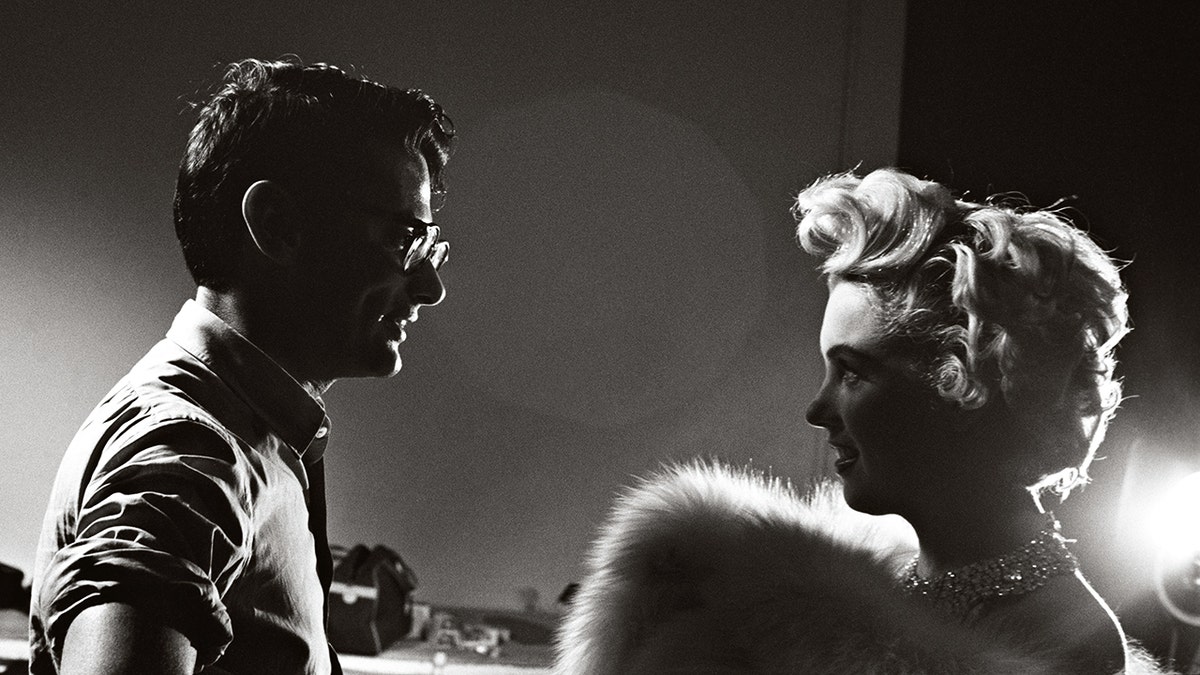 Richard Avedon chatting with a glamorous Marilyn Monroe.