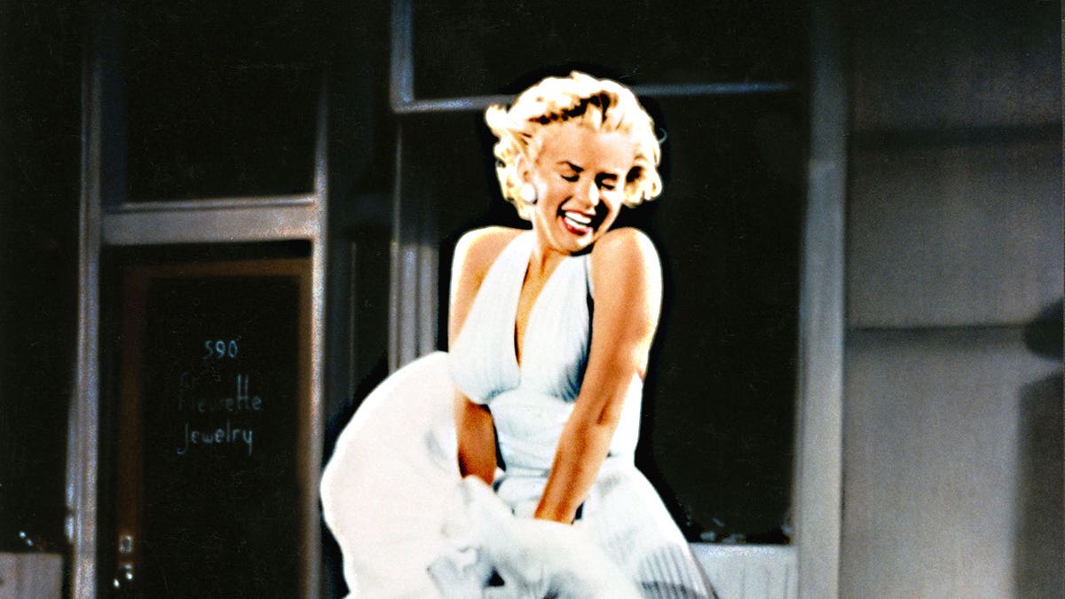 Marilyn Monroe laughing as she attempts to hold down her white dress during the filming of "The Seven Year Itch."