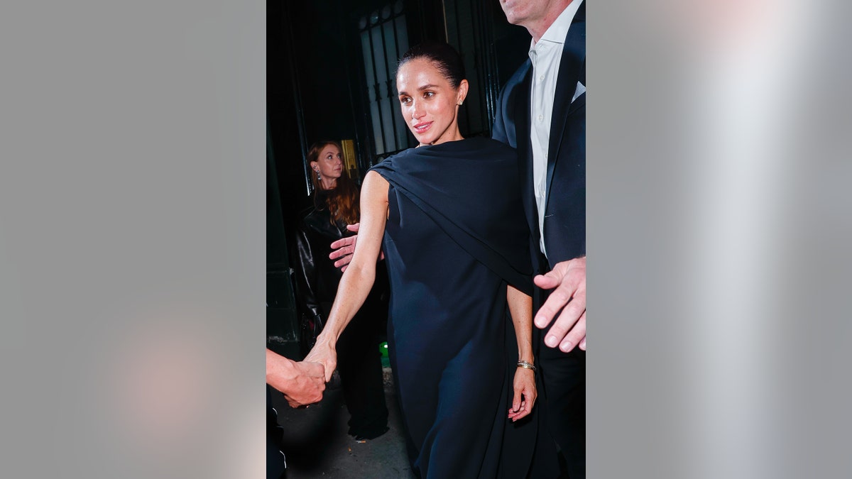 Meghan Markle has her hand being held.