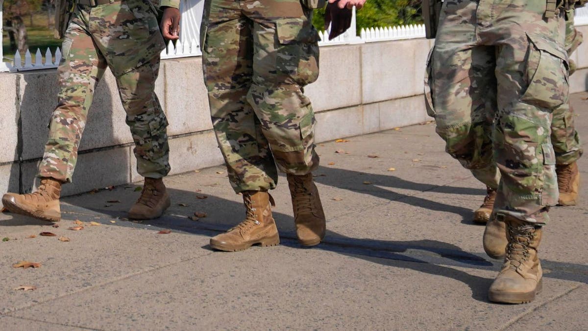 National Guard soldiers walking in uniform on a city street.