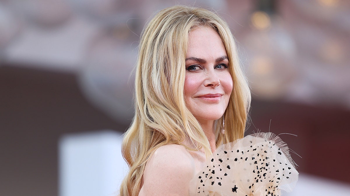 Nicole Kidman smiles and poses over her shoulder on the red carpet at the 81st Venice Film Festival in 2024.
