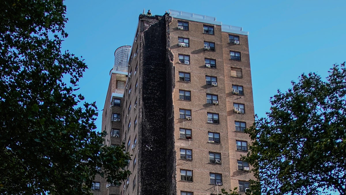 Firefighter stands on roof of partially collapsed building in New York City