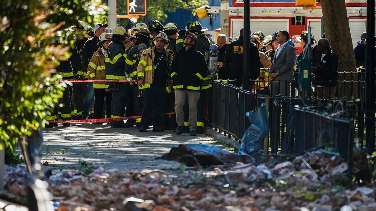 Firefighters look up at partially collapsed building in NYC
