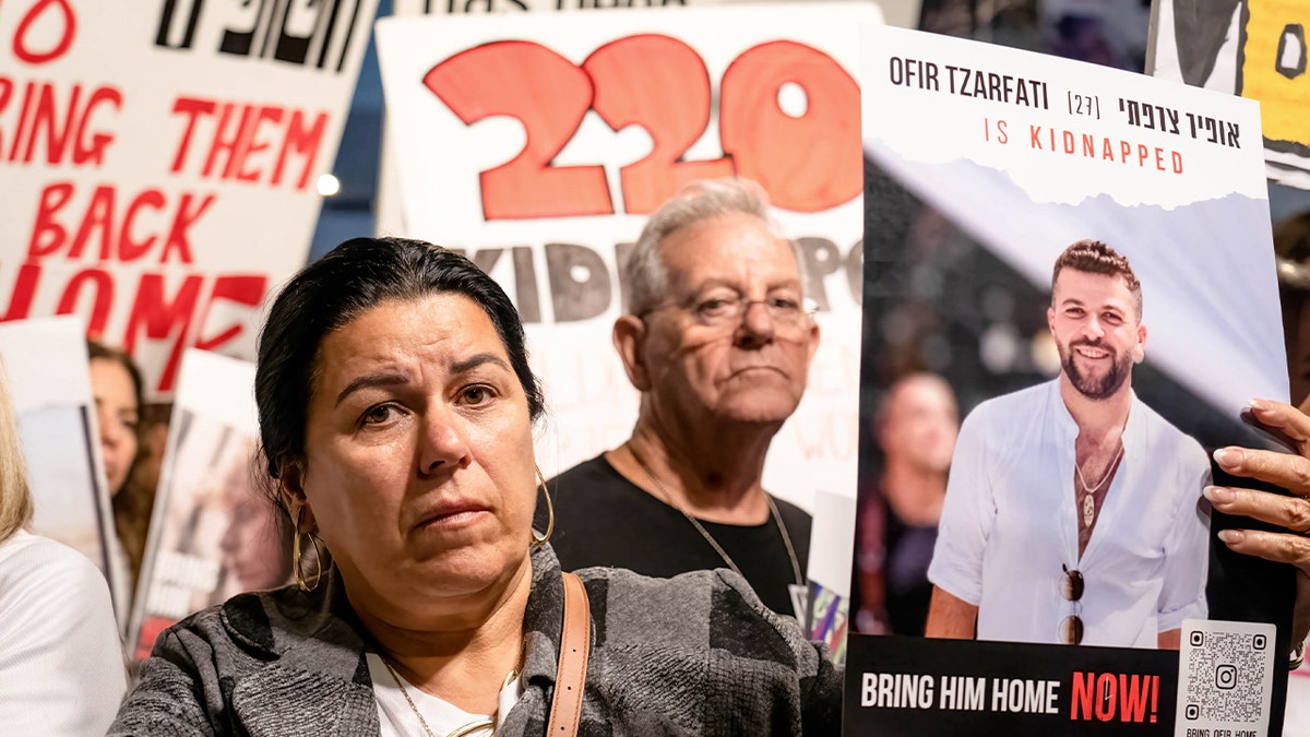 Protester holds an image of Ofir Tzarfati