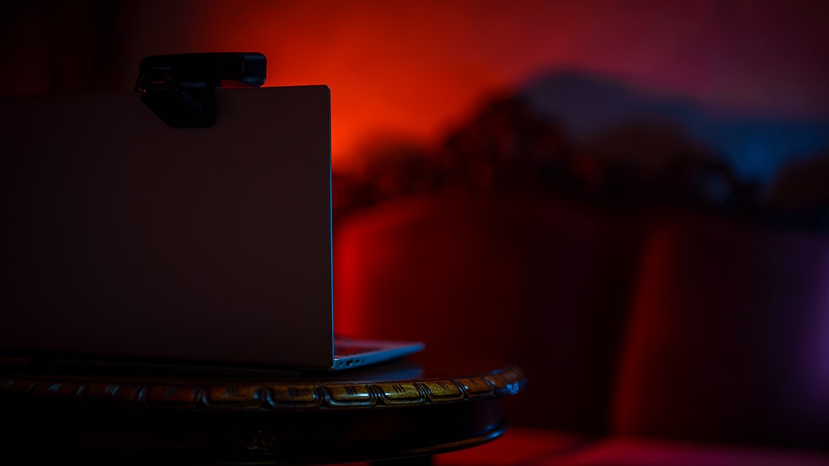 A laptop in a room illuminated by red light