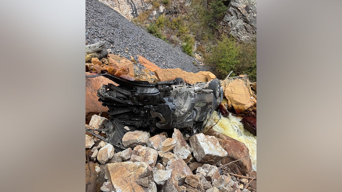 crumpled wreckage of the pickup truck on the side of the mountain