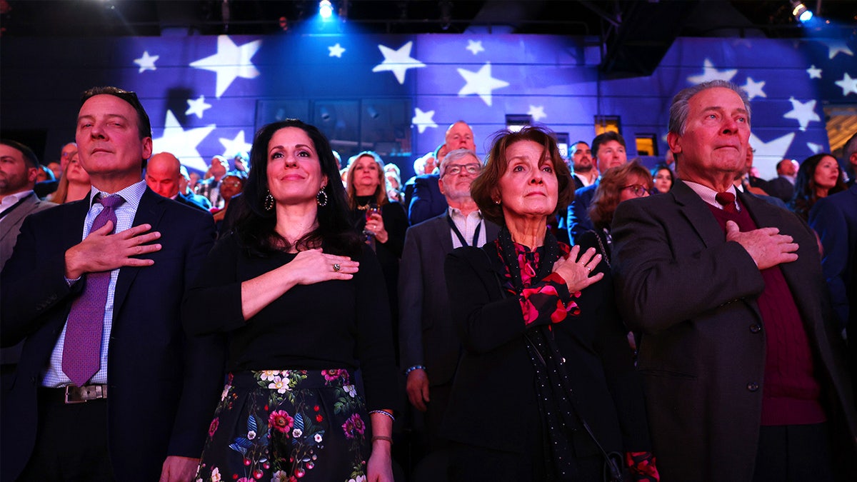 Audience members stand with hands over their hearts as the national anthem is performed at Fox Nation’s Patriot Awards.