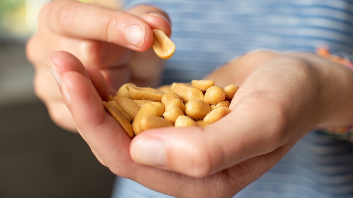 Person holding handful of peanuts